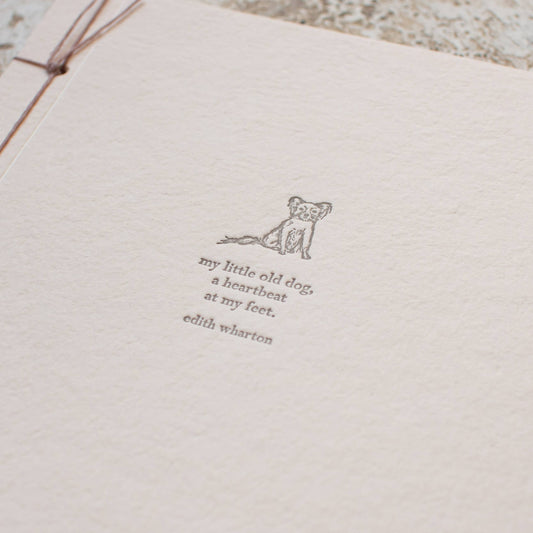 Notebook with text and a small illustration of a dog on a textured surface