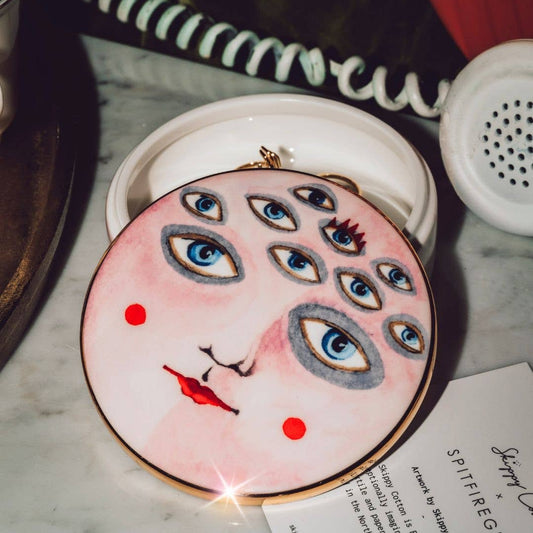 Round decorative item with face design on a marble surface