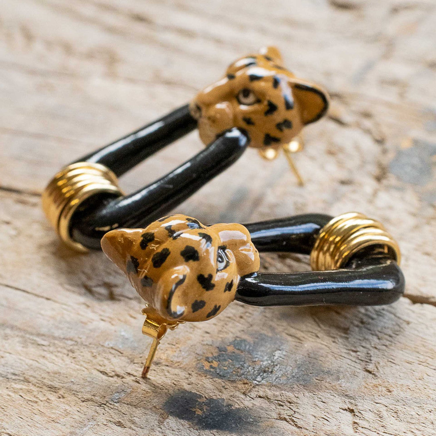 A Pair of Handpainted porcelain earrings with a leopard head design.