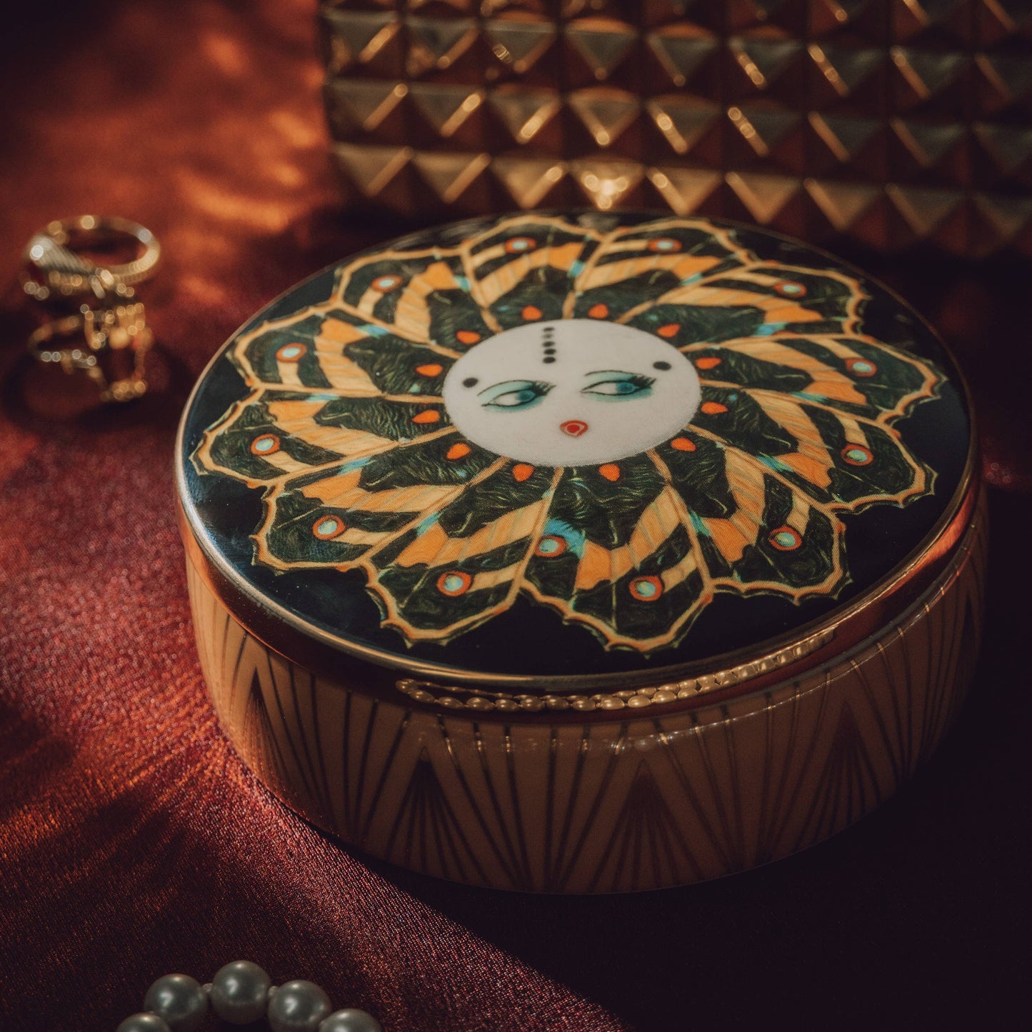 Decorative round box with intricate design on a textured surface