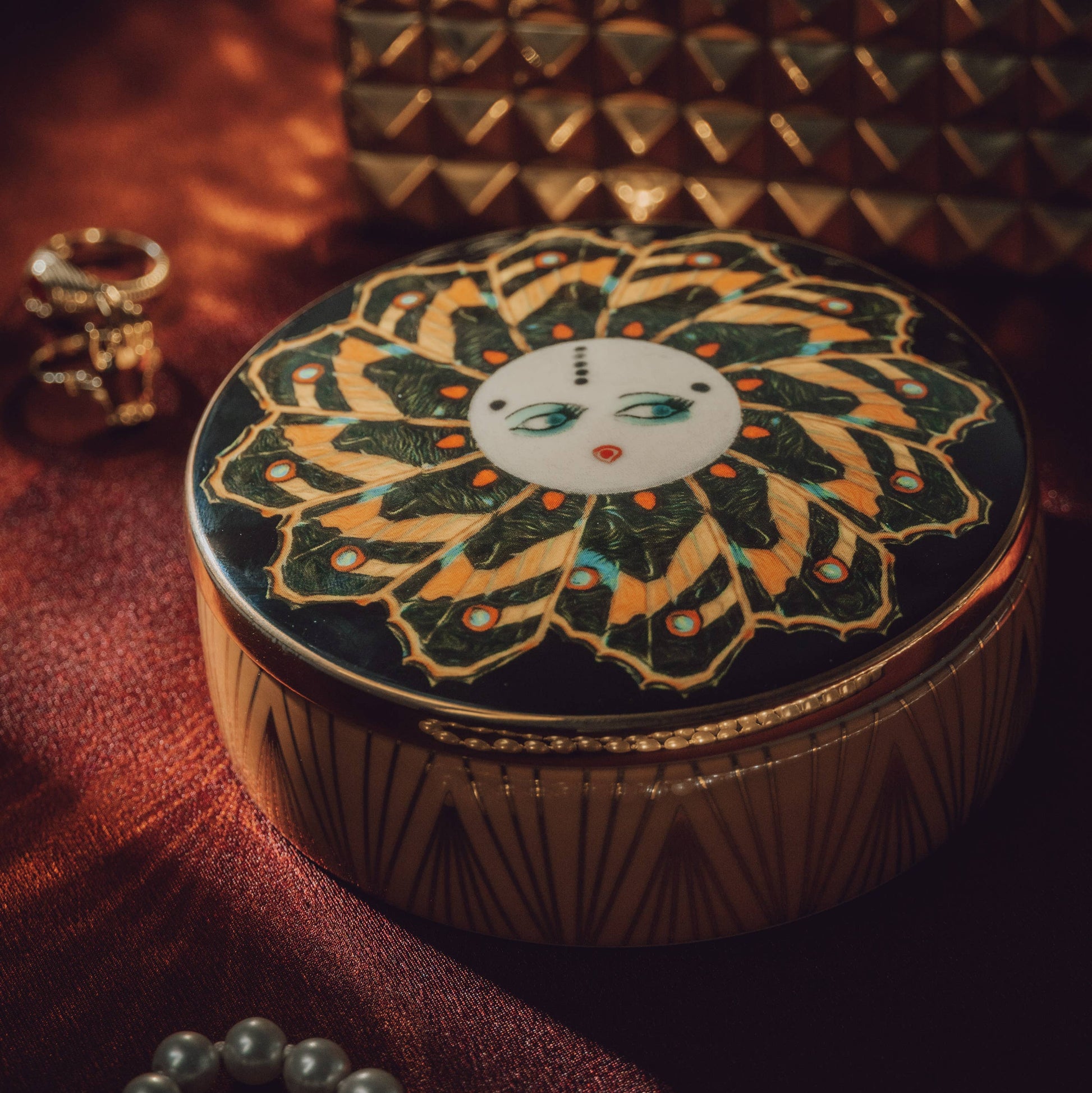 Decorative round box with intricate design on a textured surface