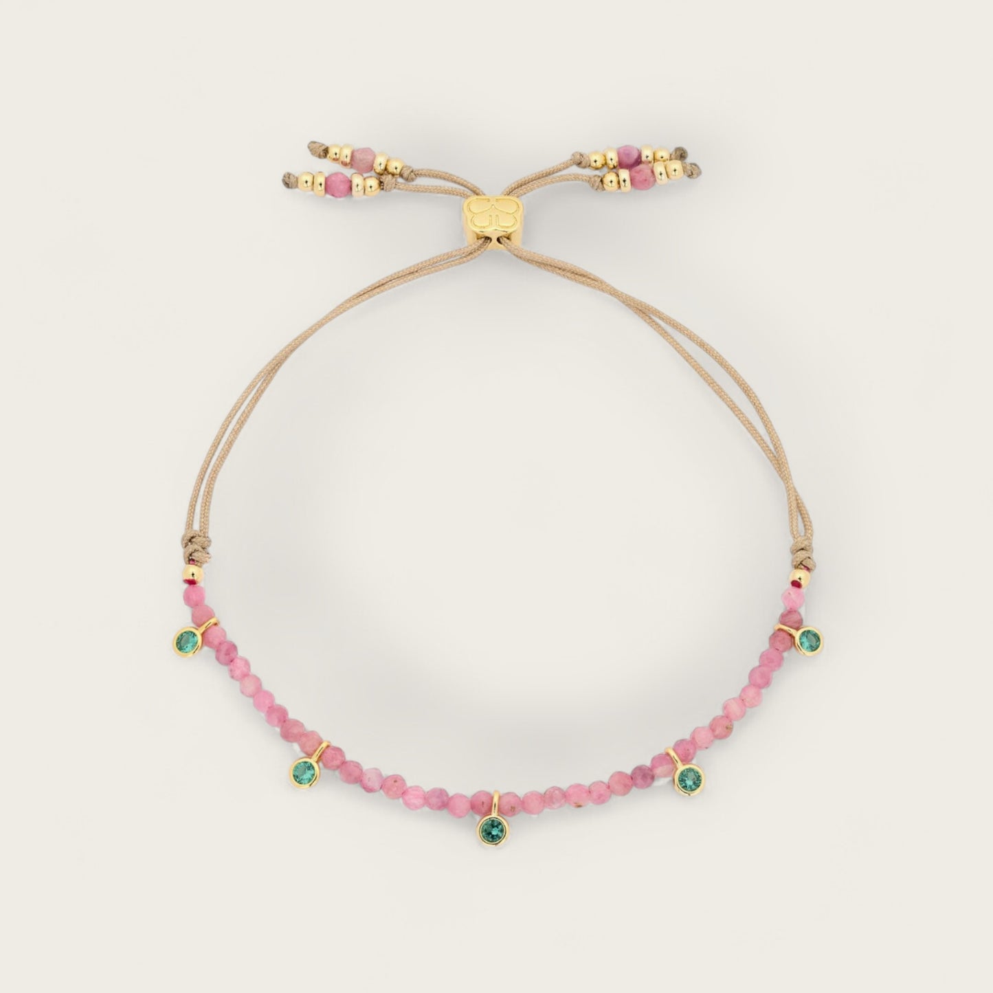 Beaded bracelet with pink and green beads on a beige background