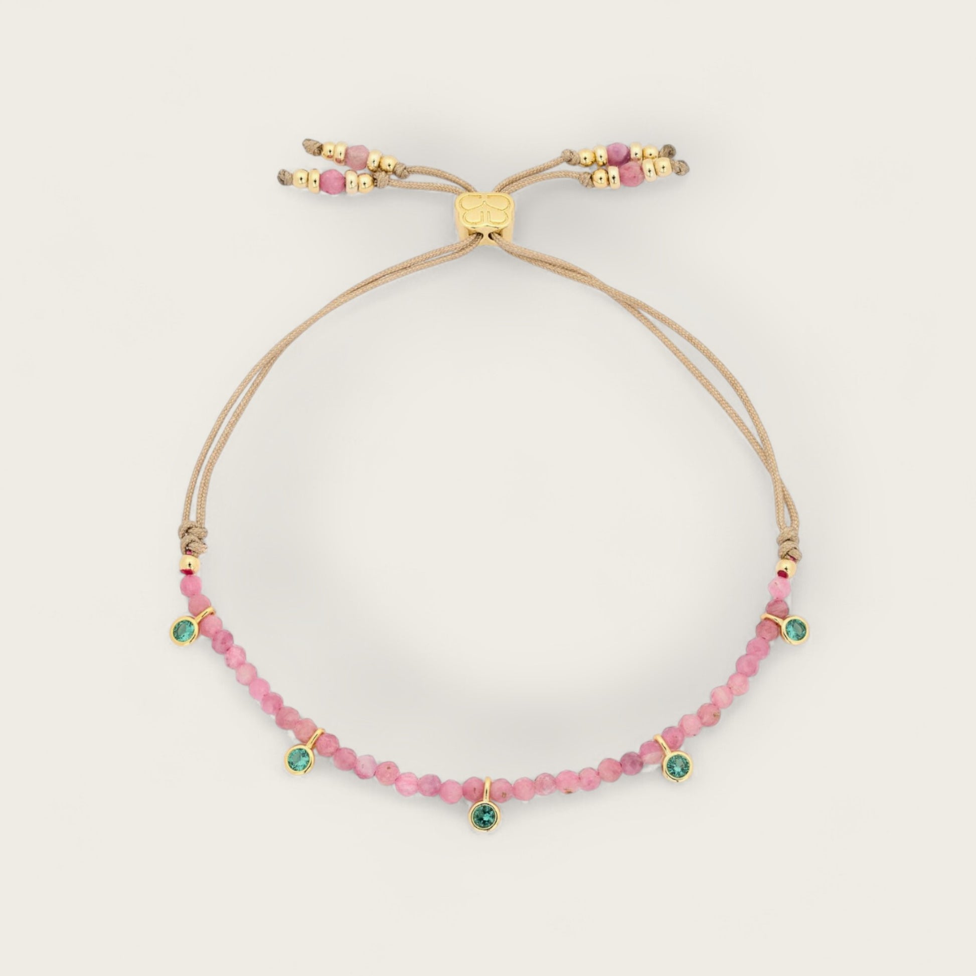 Beaded bracelet with pink and green beads on a beige background