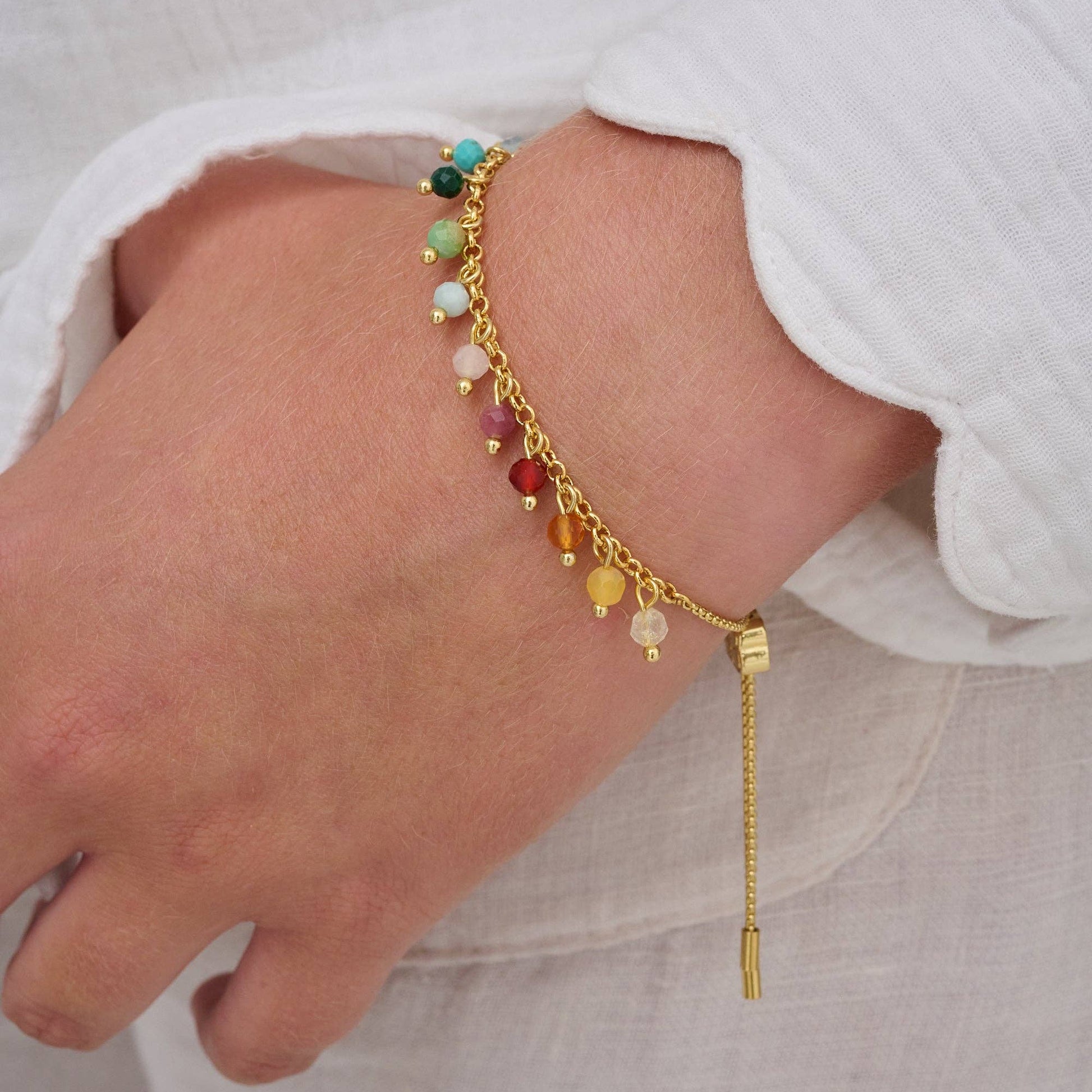 Bracelet with colorful beads on a person's wrist against a white background