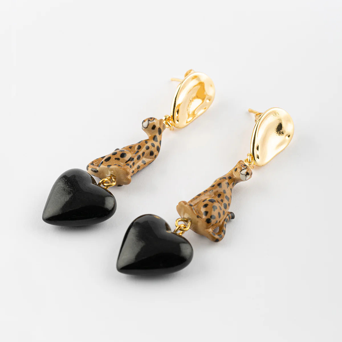 Pair of earrings with black heart-shaped pendants and gold accents on a white background