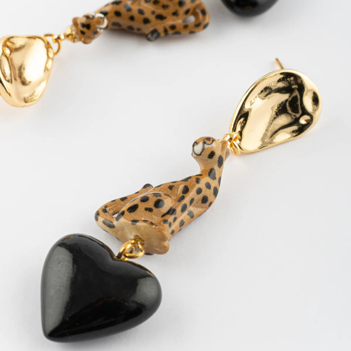 Necklace with heart-shaped black stones and animal print pendants on a white background