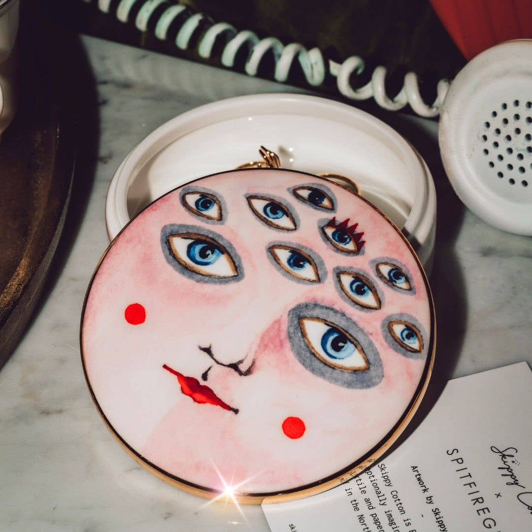 Round decorative item with face design on a marble surface