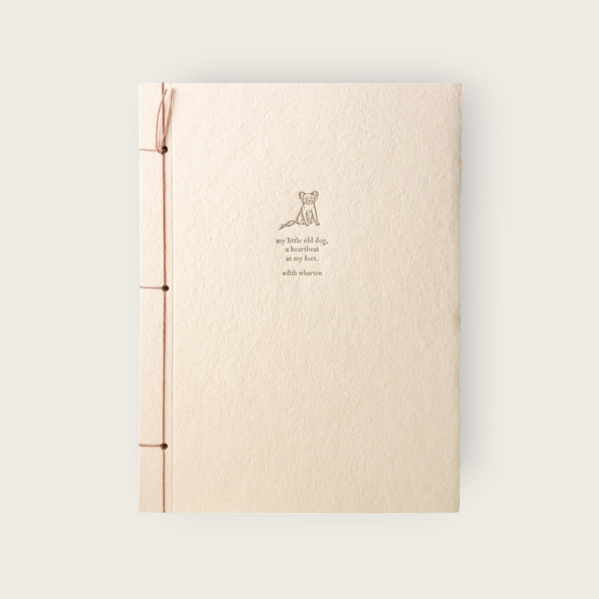 Beige notebook with a small illustration and text on a light gray background