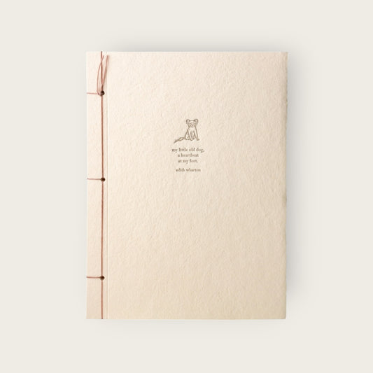 Beige notebook with a small illustration and text on a light gray background