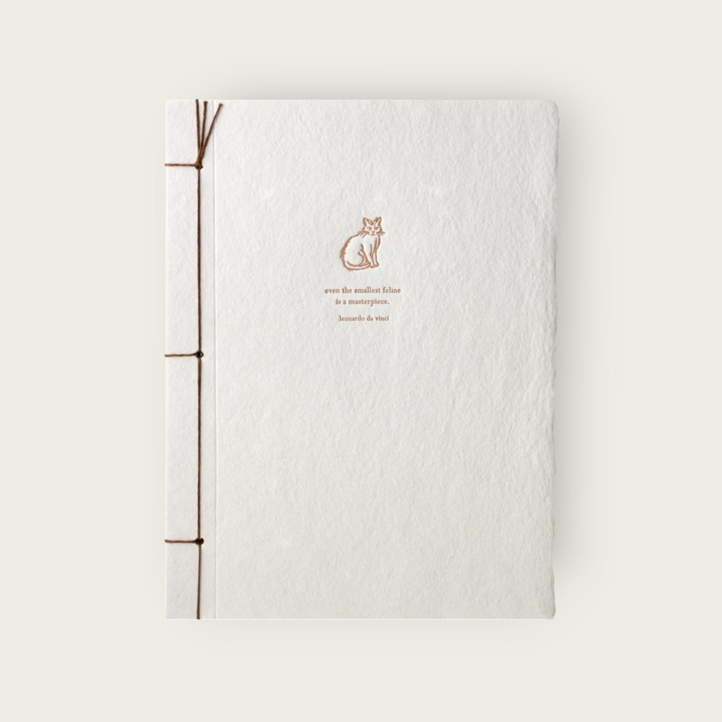 White notebook with brown binding and a cat illustration on a light beige background