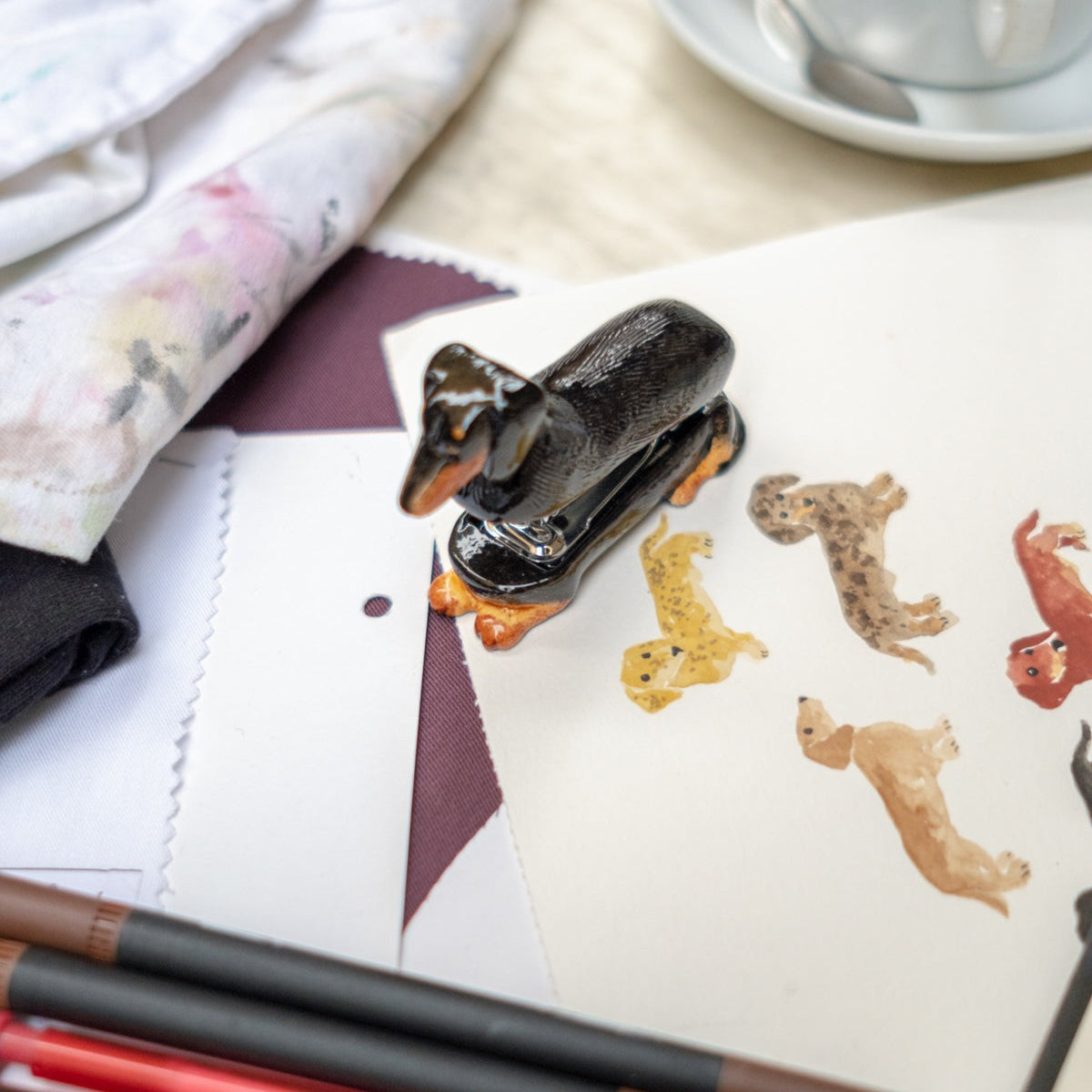 Desk with stationery items including pens, a stapler, and decorative animal stickers.