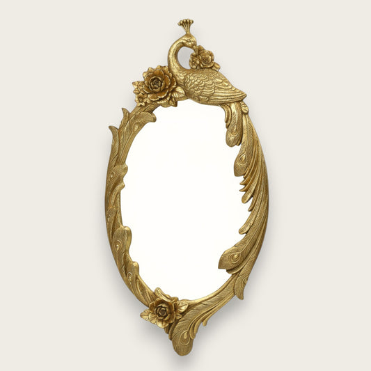 Decorative gold mirror with peacock and floral design on a white background